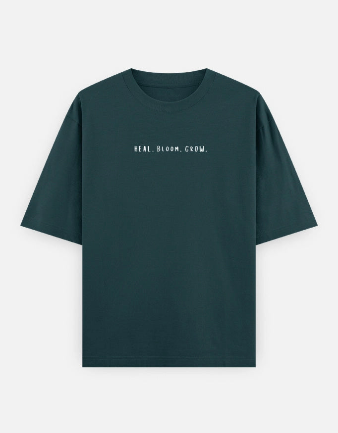 Front view of The Unserious Studio oversized unisex Heal. Bloom. Glow tee with bold graphic design and relaxed fit.