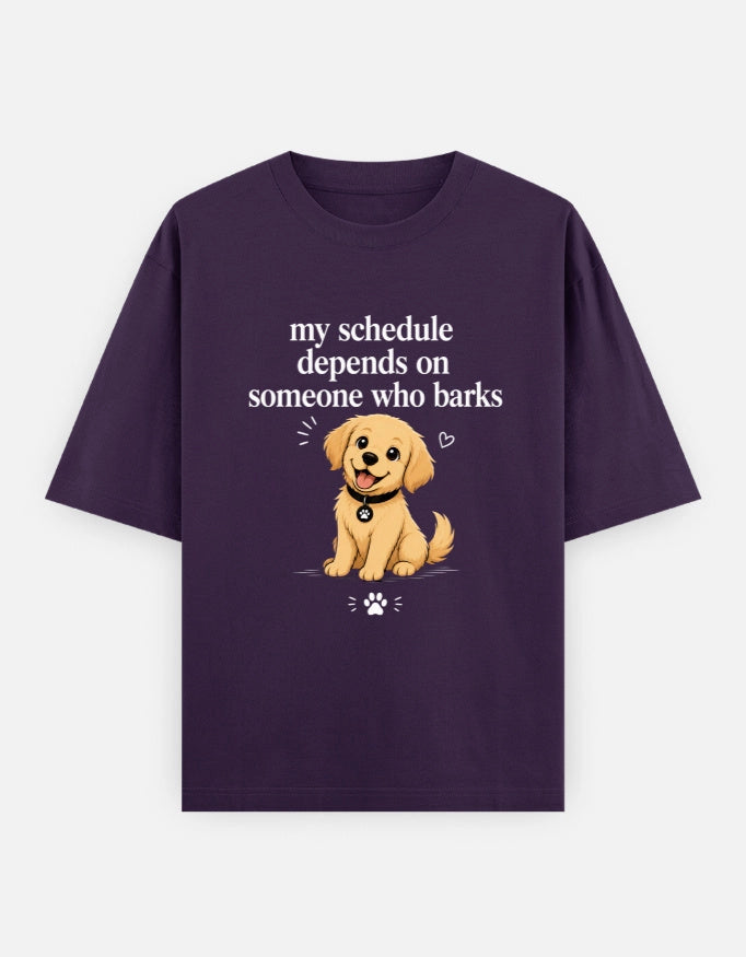 Front view of The Unserious Studio unisex oversized tee with humorous "My Schedule Depends on Someone Who Barks" print.