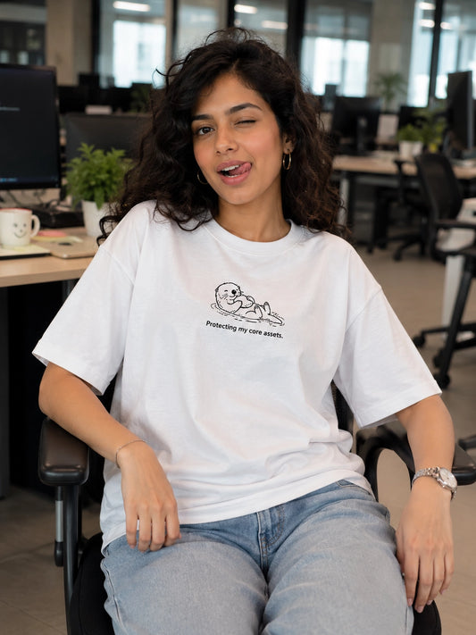 Woman wearing a white t-shirt with a graphic design  Protecting my assets sitting in an office.