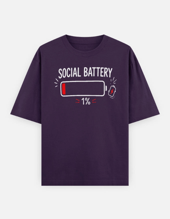 Unisex oversized tee by The Unserious Studio featuring a front design with "Social Battery 1%" text on a casual black fabric.