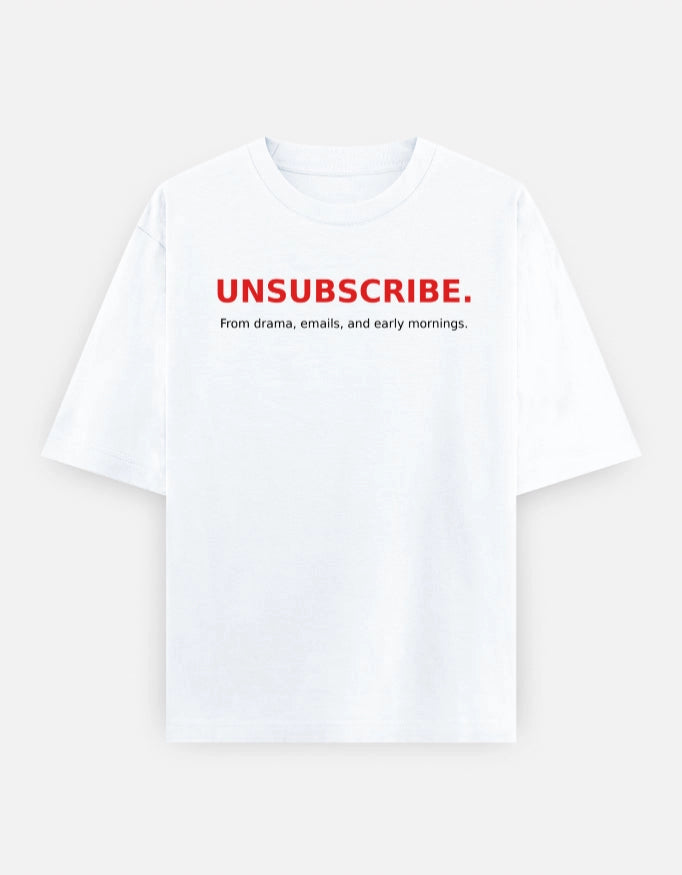 Front view of The Unserious Studio oversized unisex tee with "Unsubscribe from Office Drama" slogan in black on white fabric.