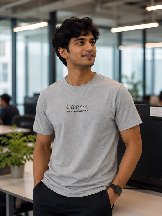 Man wearing a gray t-shirt with text in an office setting